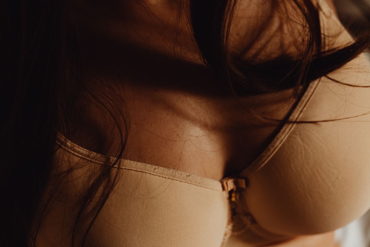 Artistic close-up of a woman in a beige bra highlighting fashion details.