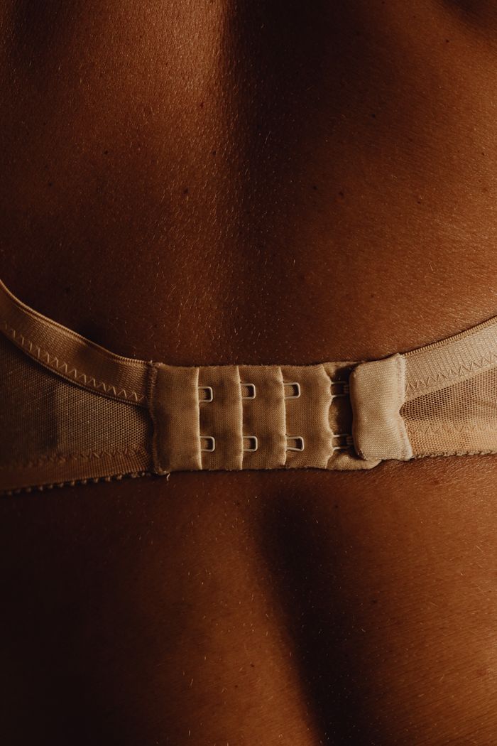A detailed close-up of a woman's back wearing lingerie, highlighting the texture and design.